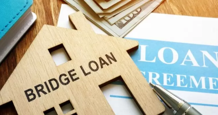 A house cut out with the words bidge loan on it on top of a contract - ECF