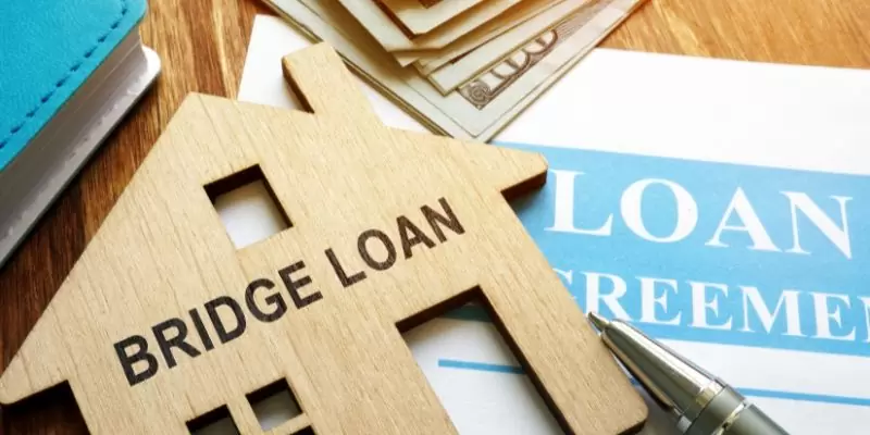 A house cut out with the words bidge loan on it on top of a contract - ECF