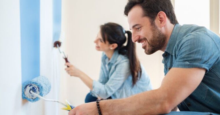 A couple painting the walls of their fix and flip property - ECF