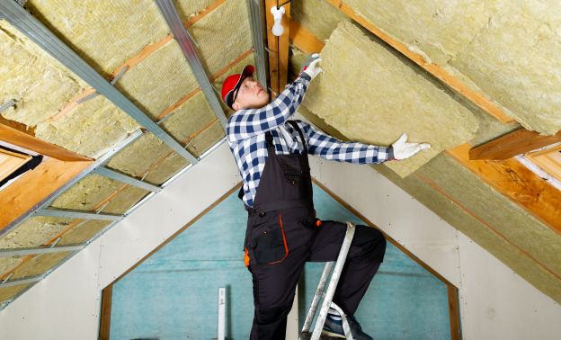Installing attic insulation in preparation for winter - Express Capital Financing