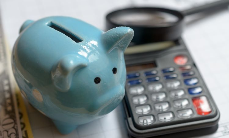 A piggy bank next to a calculator - ECF