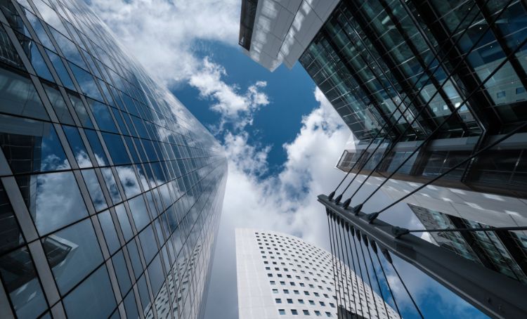 a view of skyscrapers from the ground - commercial real estate