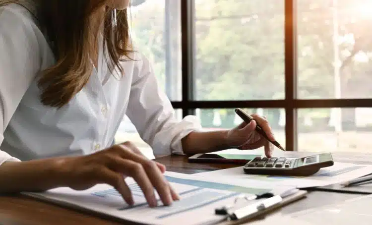 a woman checking figures on a calculator - common financing mistakes