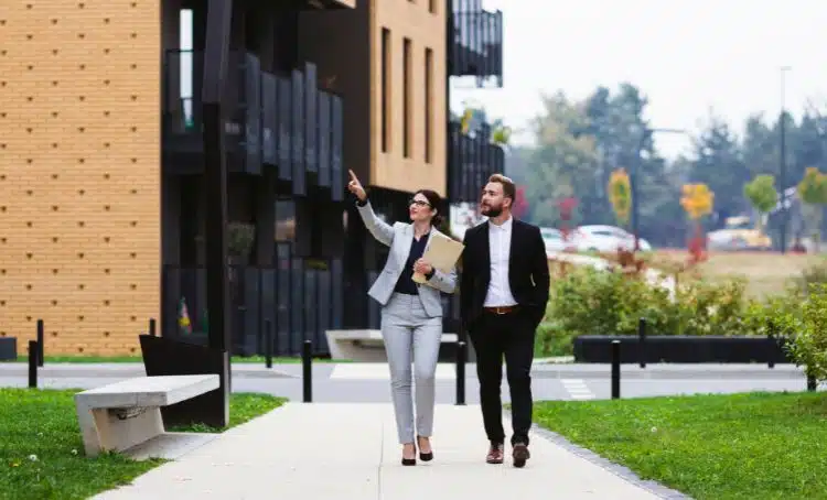 people walking down a path looking at buildings