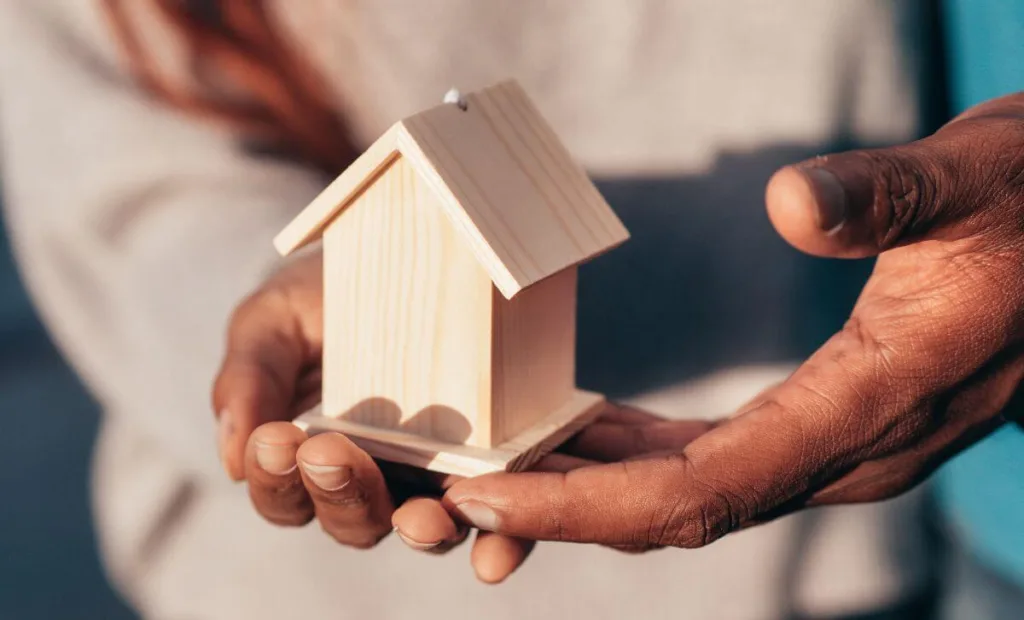Someone holding a small wooden house - Volatility of market rates - Express Capital Financing