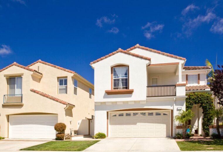 Two twin storey houses with garages on a quiet street on a sunny day - Express Capital Financing