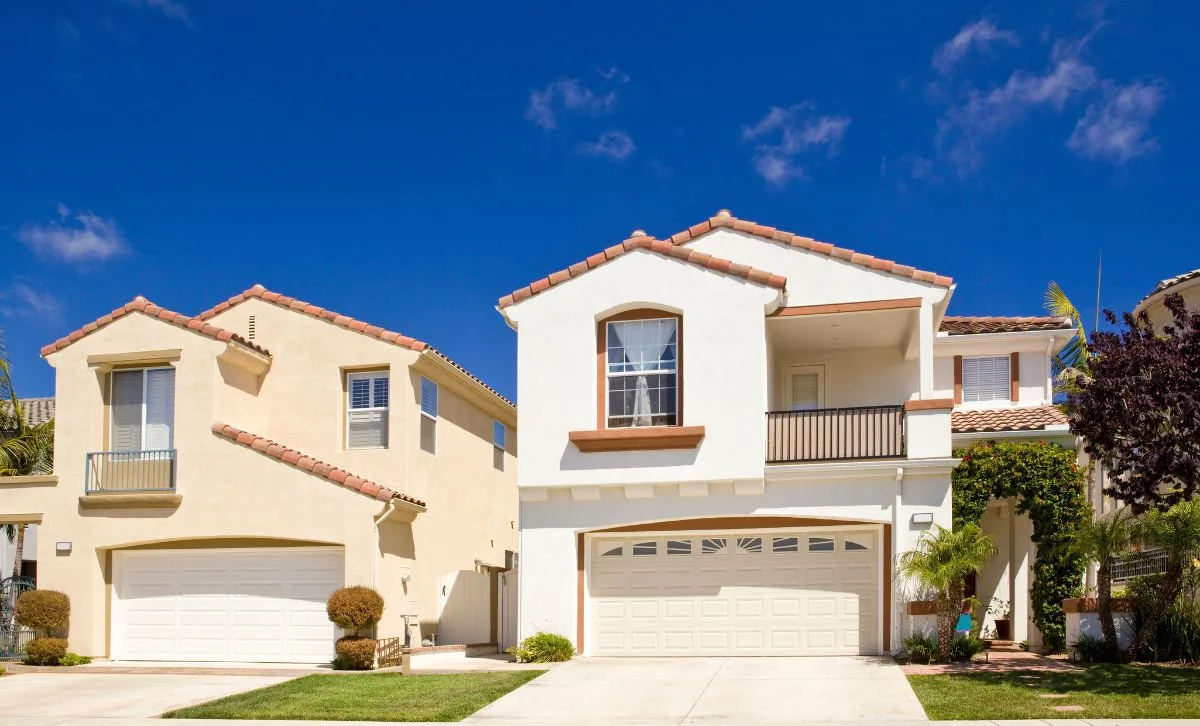 Two twin storey houses with garages on a quiet street on a sunny day - Express Capital Financing