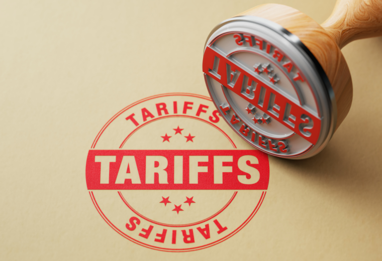A rubber stamp next to a red stamp reading tariffs on a light brown background - Express Capital Financing