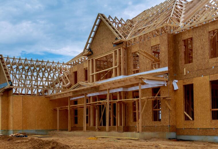 A house in the middle of being built with wooden beams and scaffolding - Express Capital Financing