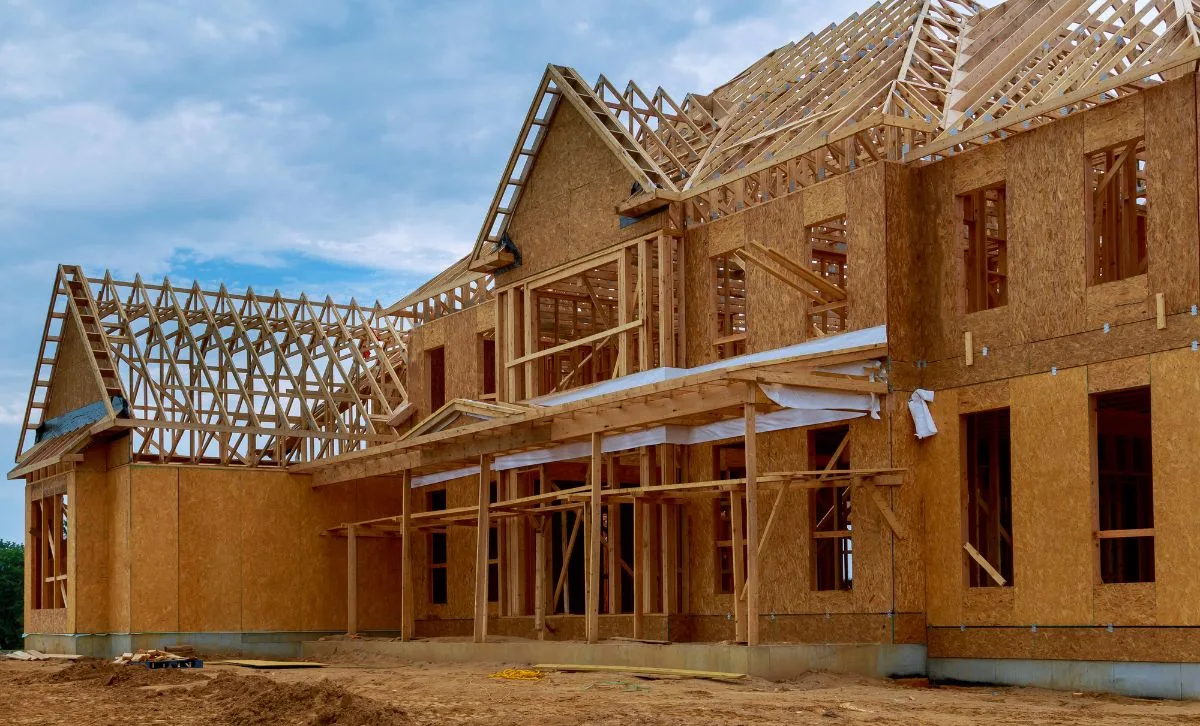 A house in the middle of being built with wooden beams and scaffolding - Express Capital Financing