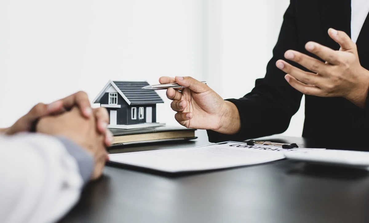 Two men discussing paperwork with a small house in the background - Express Capital Financing