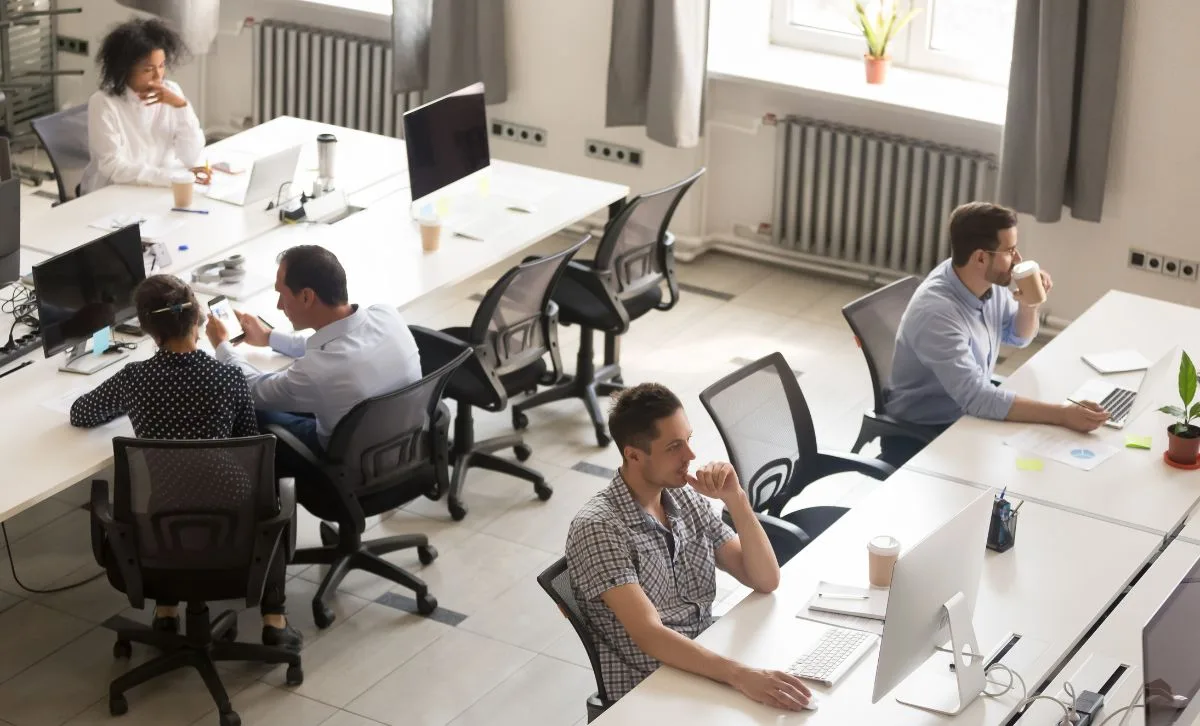 An overview shot of people sitting at desks in an open-plan office - Express Capital Financing