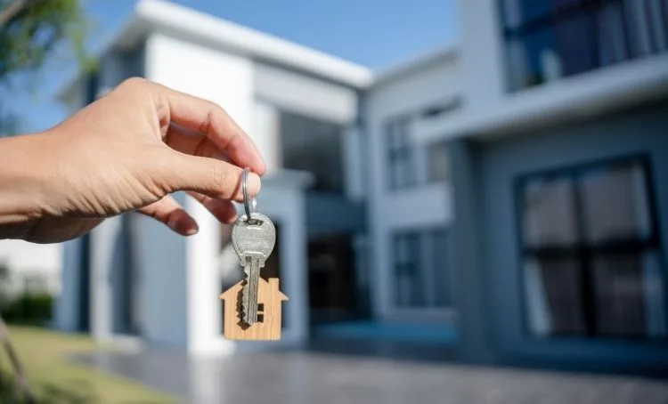 A new home owner holding the keys to a modern property after it has been fix and flipped - Express Capital Financing